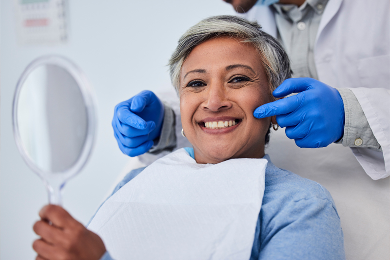 Happy senior woman, dentist pointing at her teeth