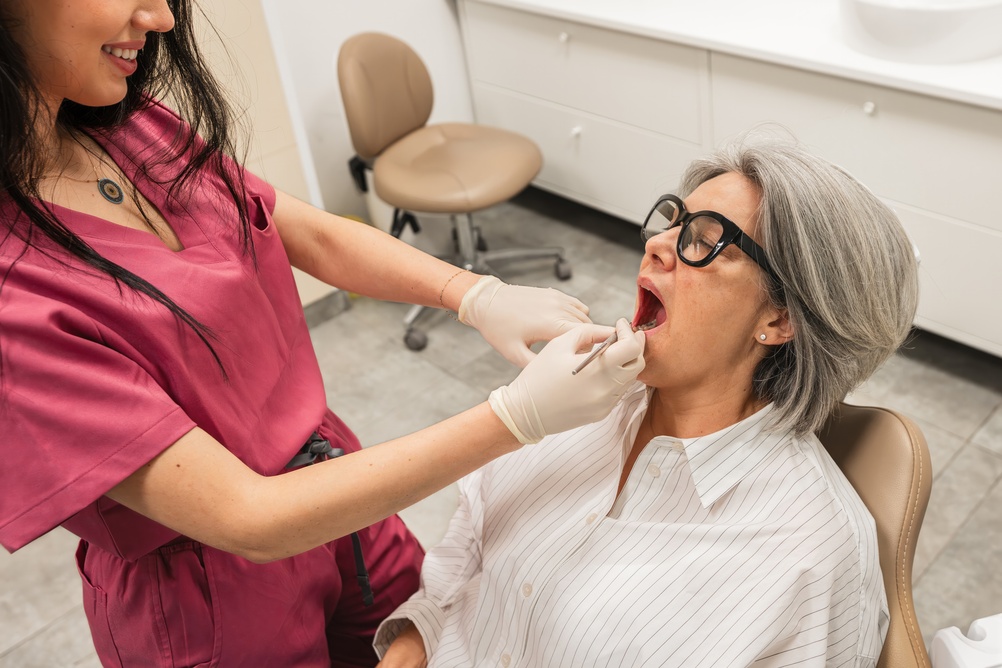 A person with a bright smile is seen biting into an apple, showcasing healthy teeth with porcelain veneers. The text on the image reads "Are Veneers Unhealthy?"