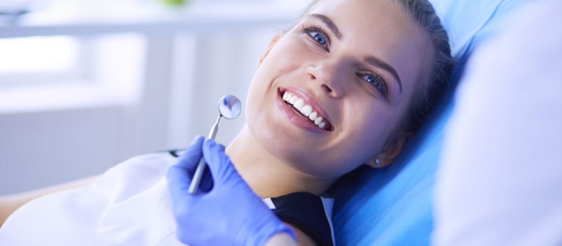 a new dental patient smiling during a dental examination.