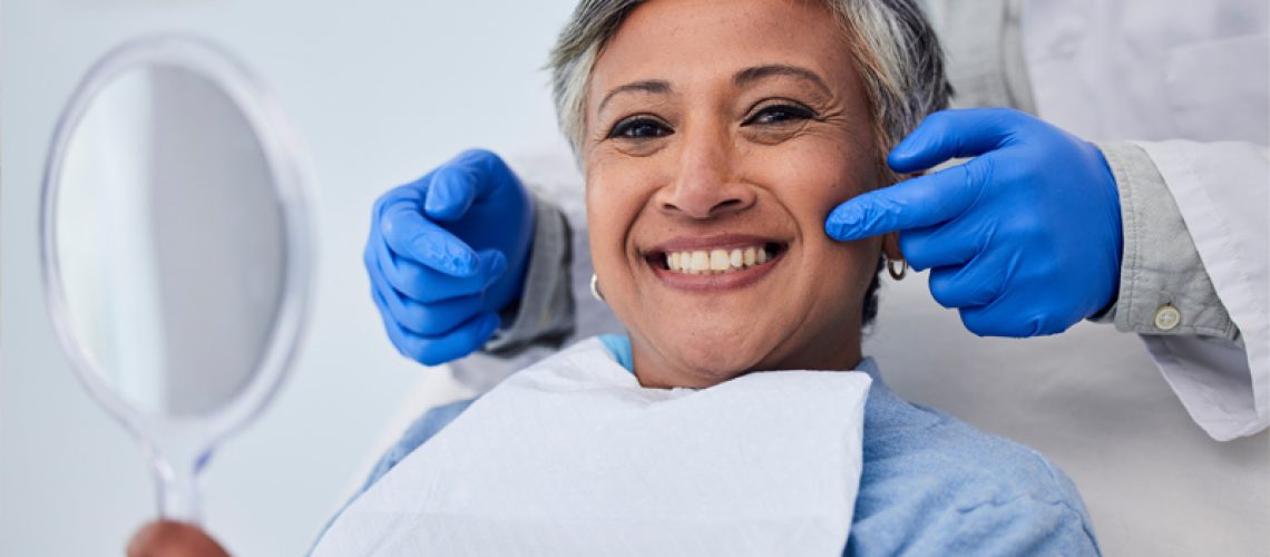 Happy senior woman, dentist pointing at her teeth